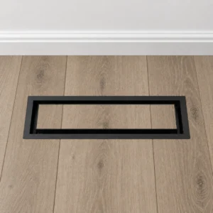 Centered black rectangular floor vent cover with matching gray oak flooring